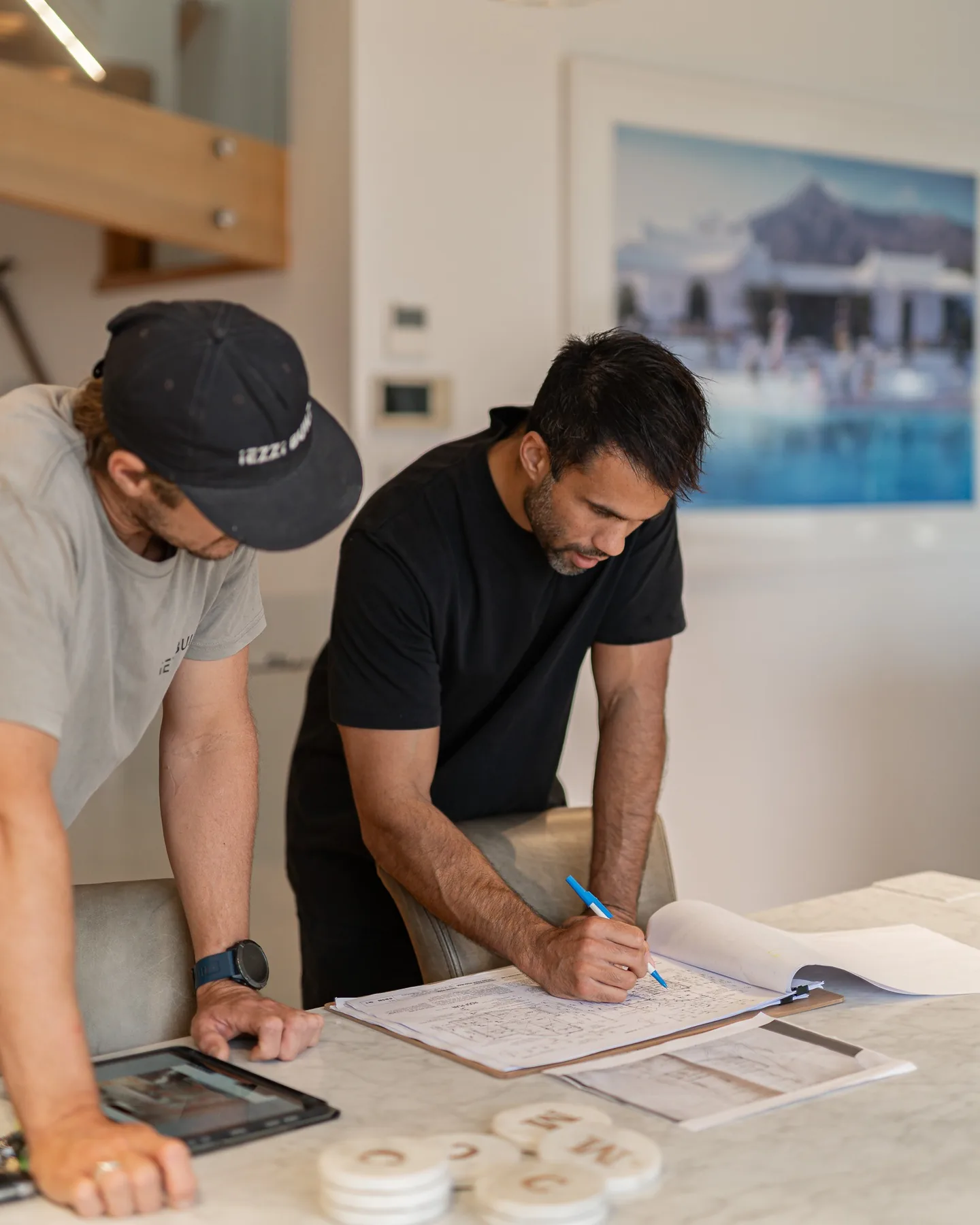 Two people leaning over a set of plans
