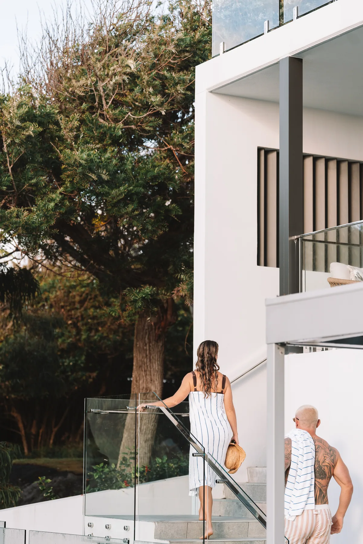 A white beach house behind coastal trees