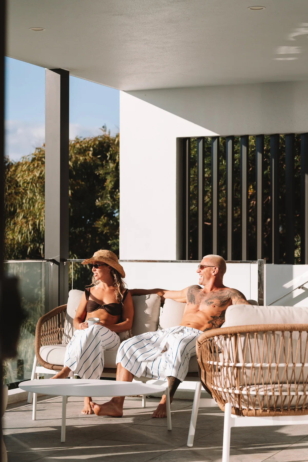 Two people sitting on a balcony above the garden