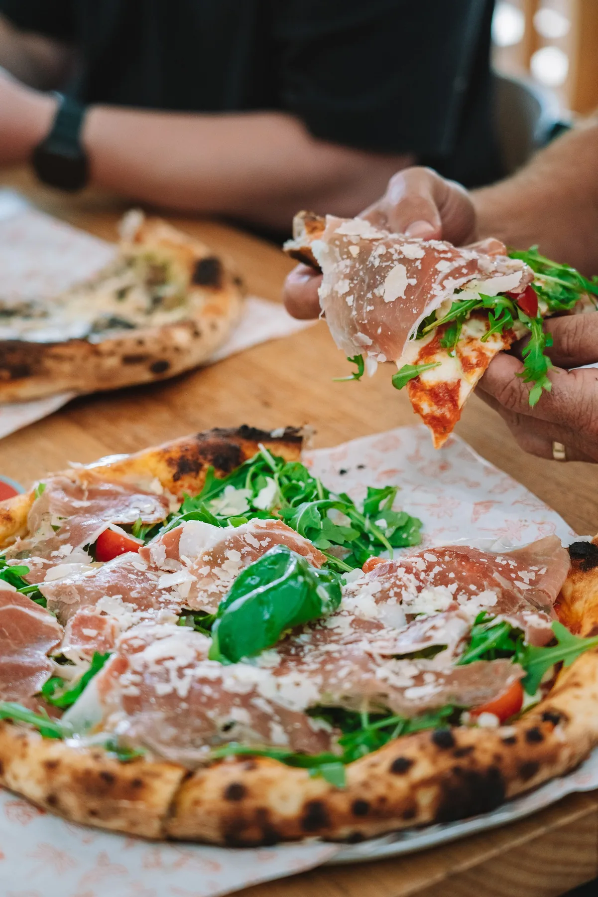 A wood fired pizza on a bench, half served