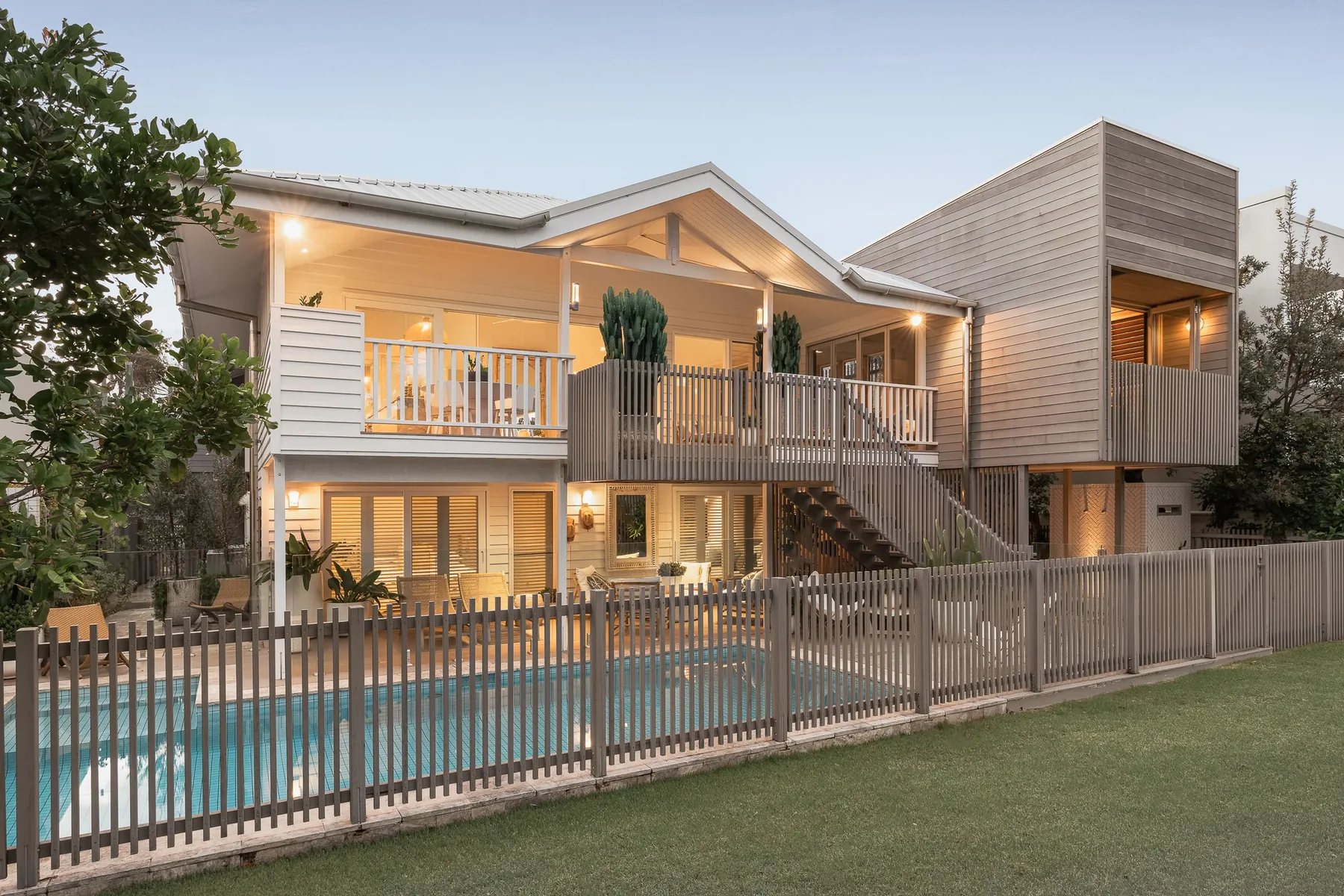 A Queenslander with a pool, lit at dusk