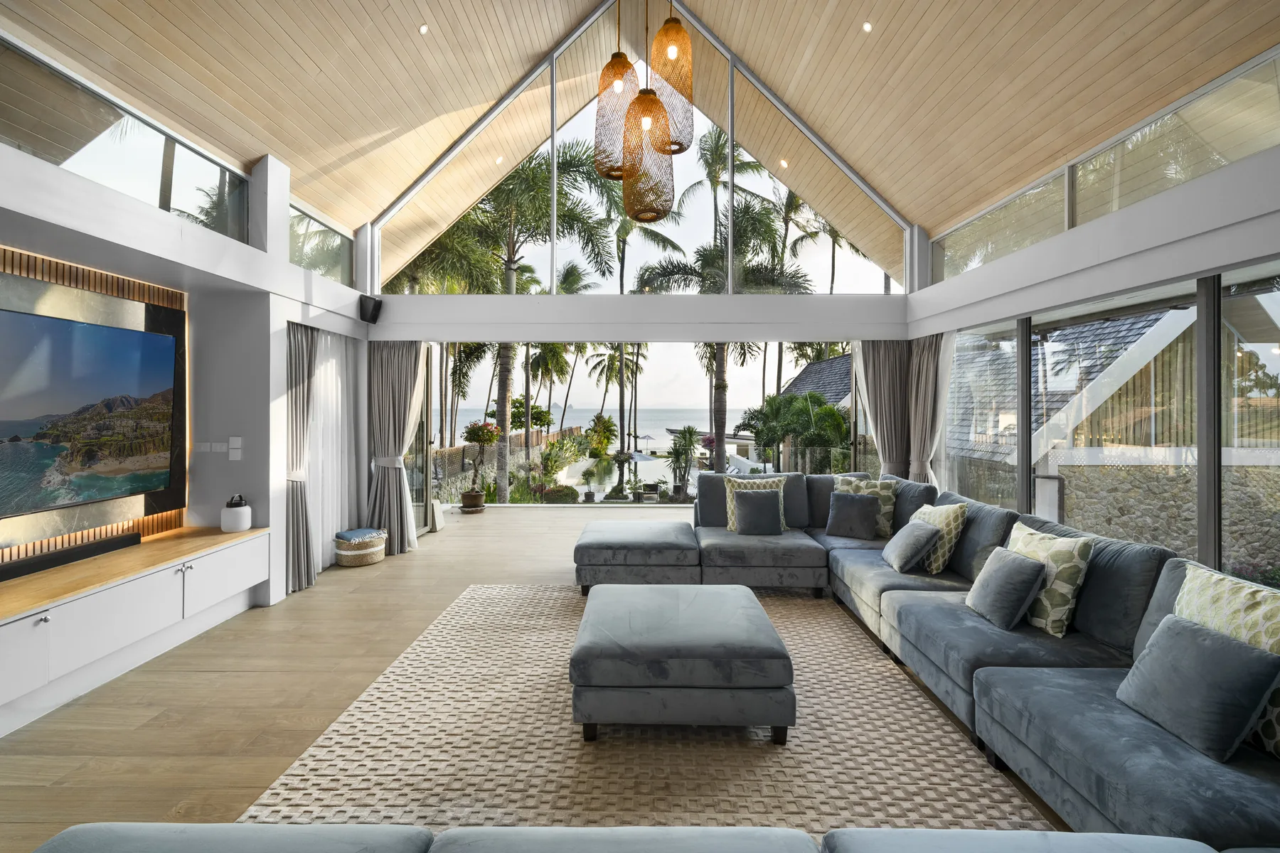 An open living pavilion looking out to palms and the sea