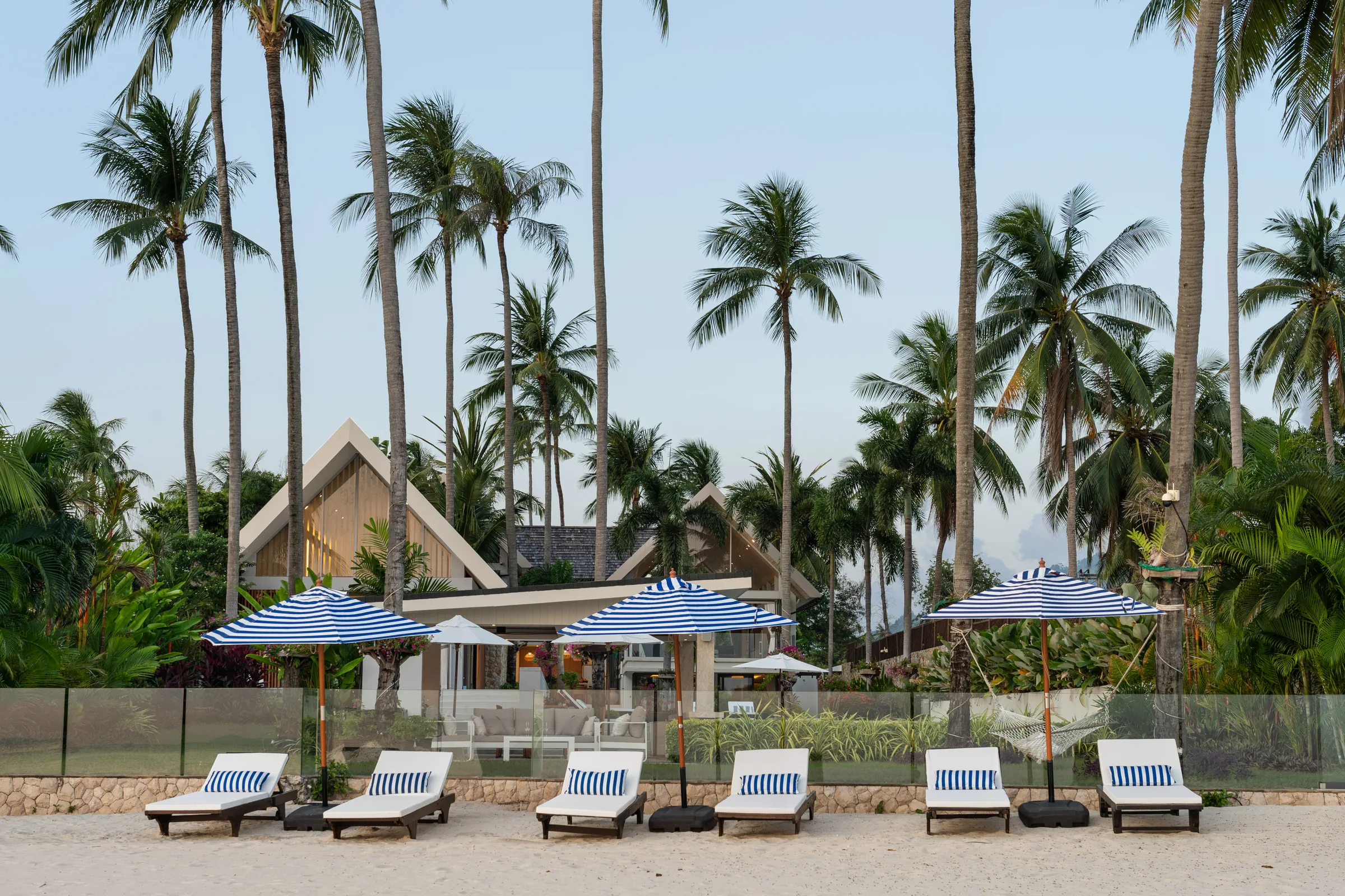 Loungers and umbrellas on a lawn running down to the sand